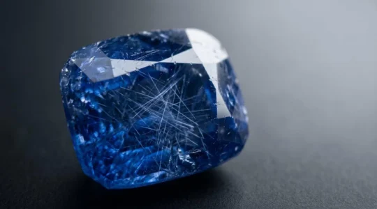 Gros plan sur un saphir bleu naturel révélant des inclusions cristallines caractéristiques